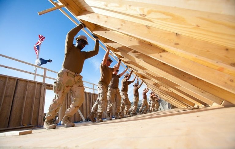 Carpinteros fijando paneles SIP en la estructura del segundo piso de una vivienda